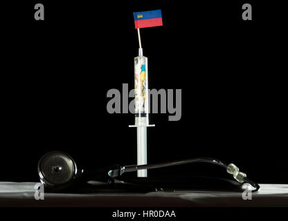 Stethoscope and syringe filled with drugs injecting the Liechtenstein flag on a black background Stock Photo