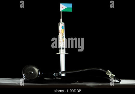 Stethoscope and syringe filled with drugs injecting the Djibouti flag on a black background Stock Photo