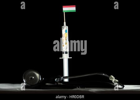 Stethoscope and syringe filled with drugs injecting the Tajikistan flag on a black background Stock Photo