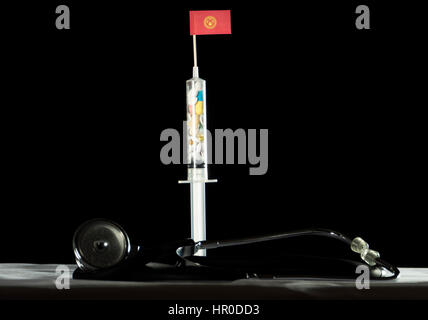 Stethoscope and syringe filled with drugs injecting the Kyrgyzstan flag on a black background Stock Photo