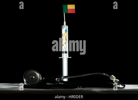 Stethoscope and syringe filled with drugs injecting the Benin flag on a black background Stock Photo