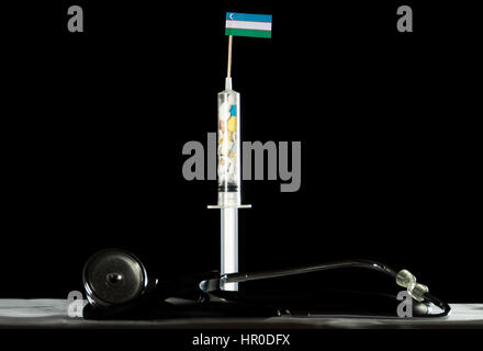 Stethoscope and syringe filled with drugs injecting the Uzbekistan flag on a black background Stock Photo