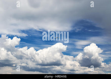 Jet plane flying in the cloudy sky jetting smoke Stock Photo