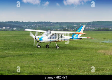 Small two-seater plane was taxiing on the runway in the field Stock Photo