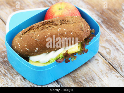 Healthy packed lunch containing brown roll with cheese and egg and red apple Stock Photo