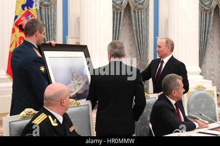Russian President Vladimir Putin is gifted a framed photograph of the Russian aircraft carrier Admiral Kuznetsov in action off Syria during a meeting with officers from the Northern Fleet at the Kremlin February 23, 2017 in Moscow, Russia. Putin meet with the officers who distinguished themselves in the combat against the Islamic State in the Mediterranean off the coast of Syria. Stock Photo
