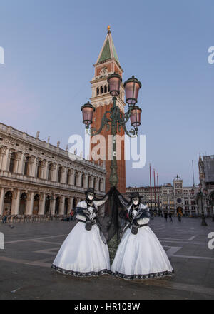 Venice, Italy. 26th February, 2017. People wearing carnival costumes pose during a beautiful  sunrise next to St Marks' Square in Venice, Italy. The 2017 Venice Carnival will run from 11 to 28 February and includes a programme of gala dinners, parades, dances, masked balls and music events.  Stock Photo