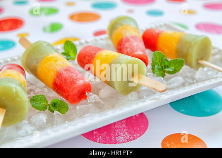 Homemade pureed fresh fruit popsicles with strawberry, mango, peach and kiwi Stock Photo