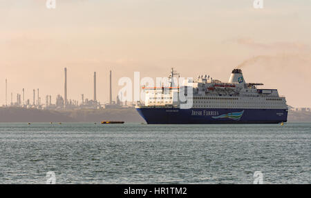 Oscar Wilde Irish Ferries vessel passes Pembroke refinery on the approach to Pembroke Dock Passenger Terminal on a calm winters morning Stock Photo