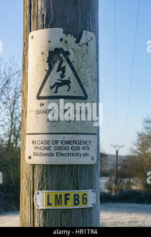 Danger of Death sign on power cable pole that has been shot many times over the years Stock Photo