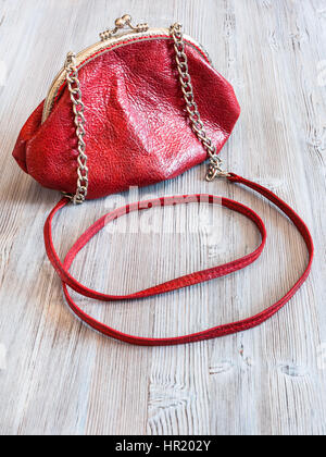 little red leather women's handbag on wooden table Stock Photo