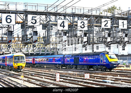 Two Firstgroup First Great Western uk train just departed Paddington railway station London UK passing under large signal gantry oversized numbers Stock Photo