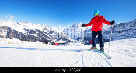 Young attractive caucasian skier with ski on ski slope in famous Jungfrau ski resort in Swiss Alps Stock Photo