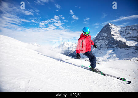 Young attractive caucasian skier with ski on ski slope in famous Jungfrau ski resort in Swiss Alps Stock Photo