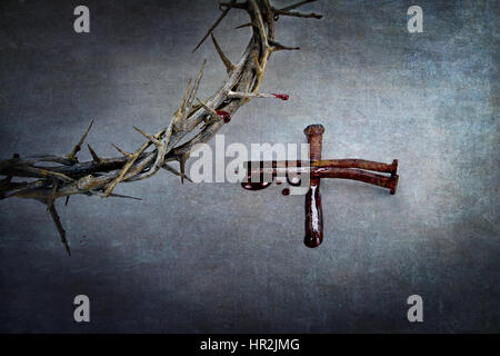 Crown of thorns and cross of naiils with blood puddled on ends. Stock Photo