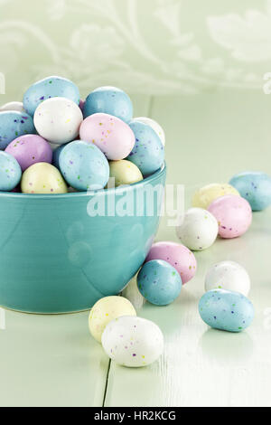 A blue bowl filled with speckled Easter candy eggs. Shallow depth of field. Stock Photo