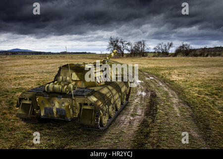 Army tank on the muddy field under the dramatic sky. 3D fantasy vehicle. Stock Photo