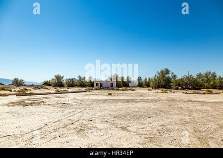 An abandoned building sits alongside the roadway near Death Valley Junction in the Funeral Mountains Wilderness Area, California. Stock Photo