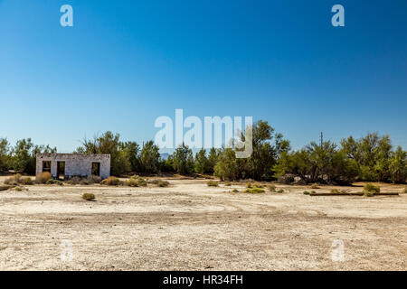 An abandoned building sits alongside the roadway near Death Valley Junction in the Funeral Mountains Wilderness Area, California. Stock Photo