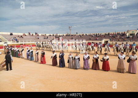 Women in Arlesian costume perform traditional dances at the bullring in Saintes Maries De La Mer during the festivities in honor of The Marquis Folco Stock Photo