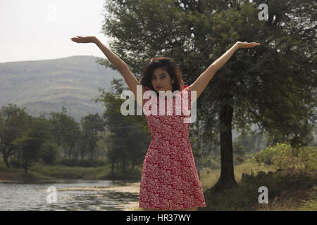 Young woman with hands raised Stock Photo