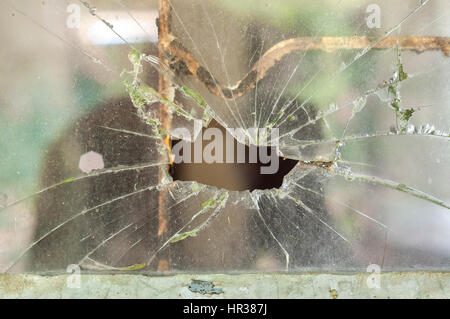 Smashed window pane with a hole in the middle Stock Photo