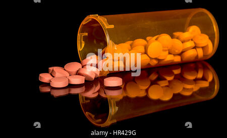 Small tan colored pills in an orange prescription bottle Stock Photo