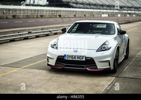 Fron angle of a white Nissan 370z Nismo on a race track, in pit lane. Stock Photo