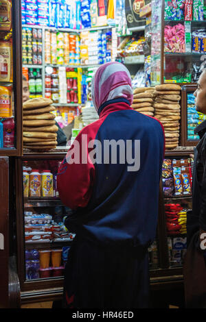 Marrakesh, Morocco.  Woman Shopping at Sundries Store, Zeitoun El-Kedim Street. Stock Photo