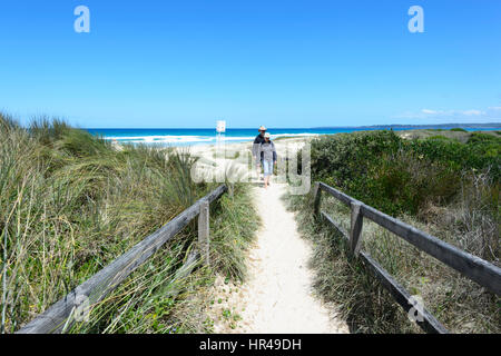 Two persons walking on the path to Conjola Beach, Shoalhaven, South Coast, New South Wales, NSW, Australia Stock Photo