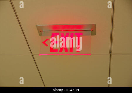 red glowing exit sign on a drop ceiling Stock Photo