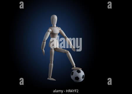 Wooden figurine stepping on soccer ball on black background with blue spotlight. Soccer game player concept Stock Photo