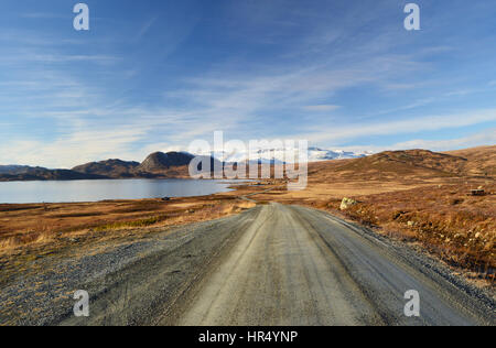 A gravel road along the lake Vinstre in Jotunheimen, Norway Stock Photo