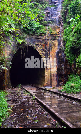 Water cascading across the entrance to an historic abandoned railway tunnel in Helensburg, Sutherland Shire, New South Wales, Australia Stock Photo