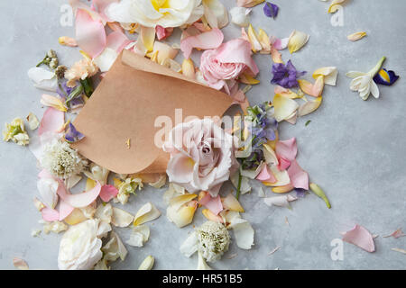 white envelope full of various flowers on a stone background . Flat lay. Love concept. flat lay Stock Photo