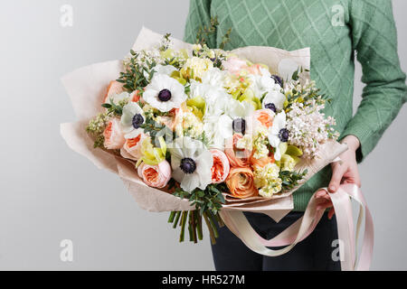 Rich bunch of pink eustoma and roses flowers, green leaf in hand Fresh spring bouquet. Summer Background. Stock Photo