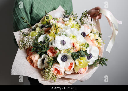 Rich bunch of pink eustoma and roses flowers, green leaf in hand Fresh spring bouquet. Summer Background. Stock Photo