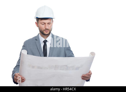 Putting plan into action. Handsome serious man wearing hardhat studying architectural blueprint he is holding isolated on white copyspace architecture Stock Photo