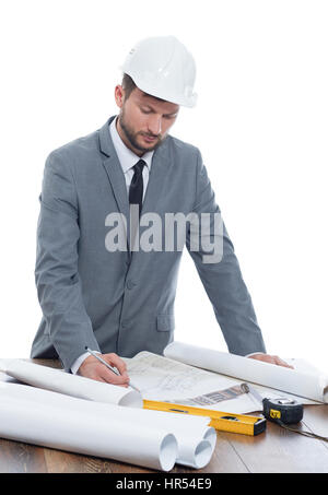 Checking on blueprints. Mature male architect developer wearing protective helmet looking concentrated and serious drawing a building plan isolated on Stock Photo