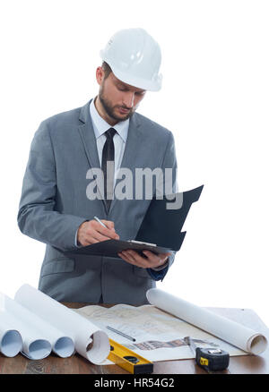 Making notes. Vertical portrait of a professional male architect in a protective hardhat making notes on his clipboard isolated profession writing inf Stock Photo