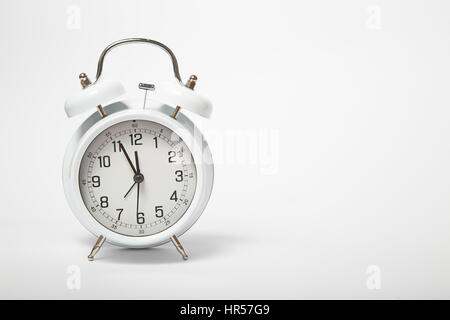 Big old vintage alarm clock with bells on white bacgrkound Stock Photo