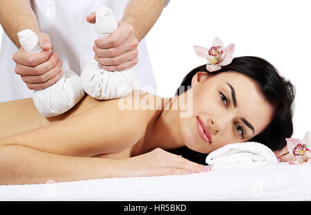 Thai Ball Massage. Woman getting SPA thai herbal compress massage. Isolated on white background Stock Photo
