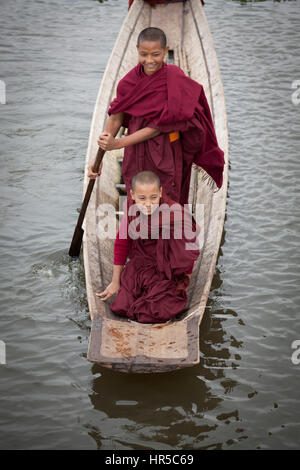 Novice Buddhist monks having fun on a small craft, at Maing Thauk (Myanmar). Young novices are also allowed to play because they are normal kids. Stock Photo