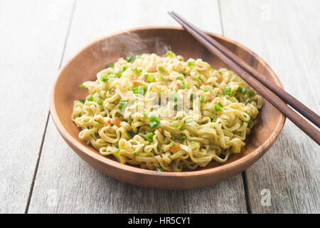 Cooked Japanese ramen dried noodles with chopsticks on wooden table. Stock Photo