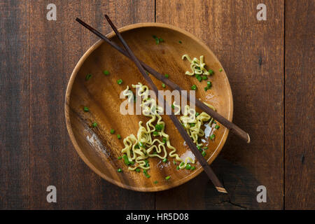 Top view leftover food dried noodles with chopsticks on rustic wooden table. Stock Photo