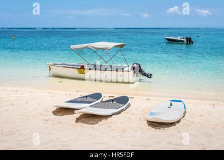 Le Morne, Mauritius - December 7, 2015: Windsurfing boards and boats on the Le Morne Beach, one of the finest beaches in Mauritius and the site of man Stock Photo