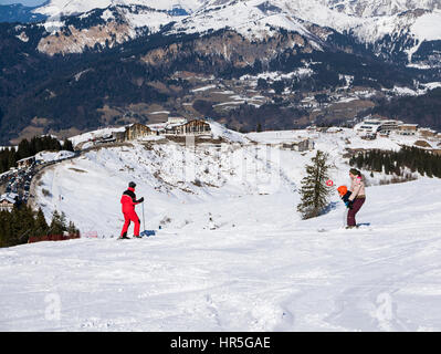 Skiers skiing on red run Marmotte in Grand Massif ski area of French Alps above Samoens, Haute Savoie, Rhone-Alpes, France, Europe Stock Photo