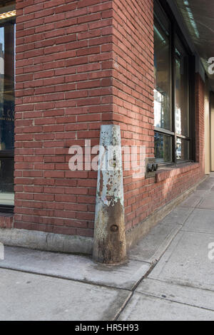 Corner of a brick building being protected by metal bumper. Stock Photo