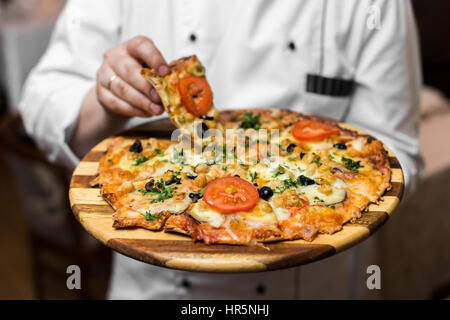White Wood Fired Neapolitan Pizza Maker Close Up Holding Silver Tray with Fresh Pie Stock Photo