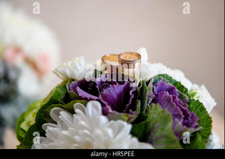 two golden rings on a wedding bouquet close up Stock Photo